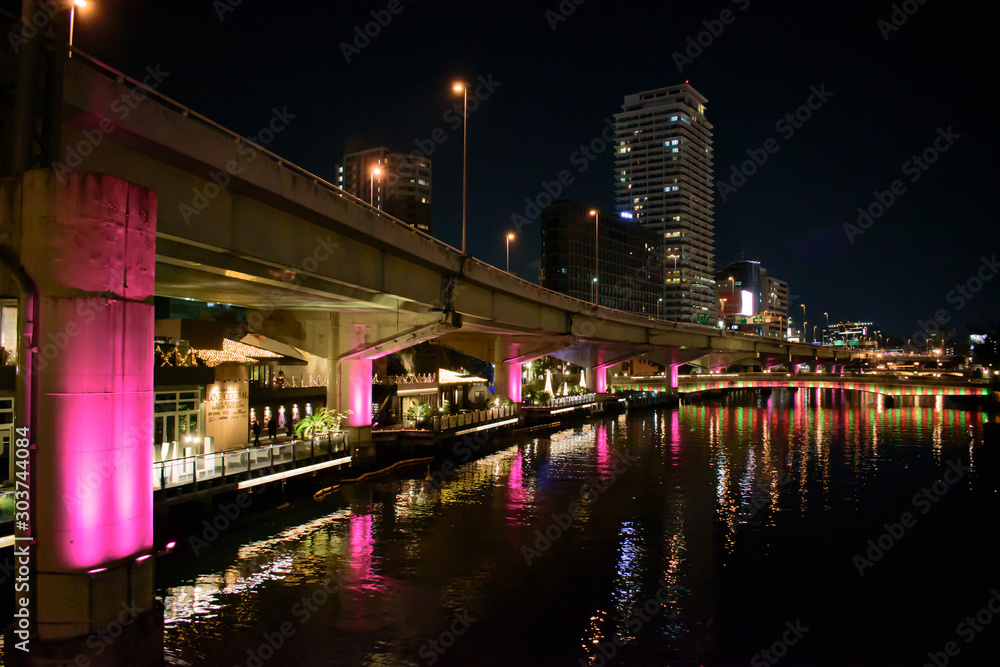 Fototapeta premium ピンク色にライトアップされた、大阪の堂島川沿いの輝く美しい夜景(光の饗宴2018)