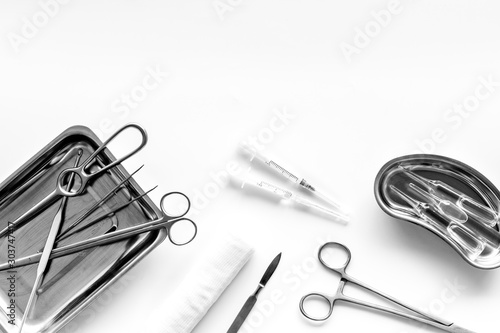 Plastic surgery instruments and tools with bandage on white background top view frame copy space
