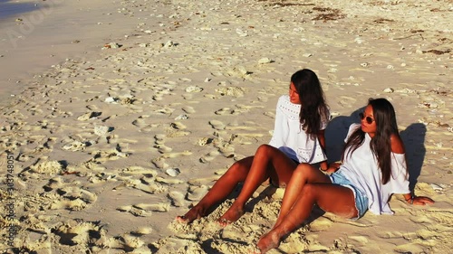 Tourists Sitting On The Beautiful White Sand Beach In Viti Levu Island Under The Heat Of A Summer Sky - Wide Shot photo