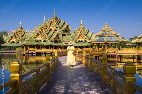A woman tourist is sightseeing beautiful golden pavilion inside Ancient city (Muang Boran) in Thailand. © BUSARA