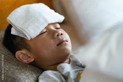 the boy using cooling gel sheet on head for medical he fever