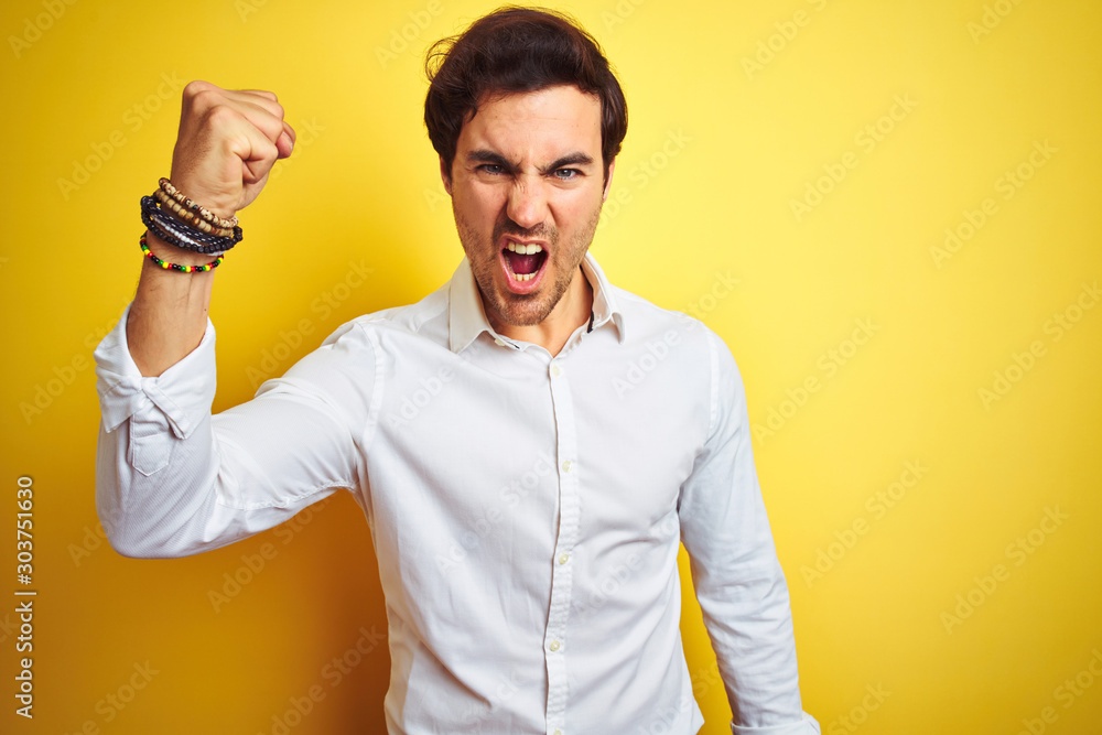 Φωτογραφία Young handsome businessman wearing elegant shirt standing over isolated yellow background angry and mad raising fist frustrated and furious while shouting with anger