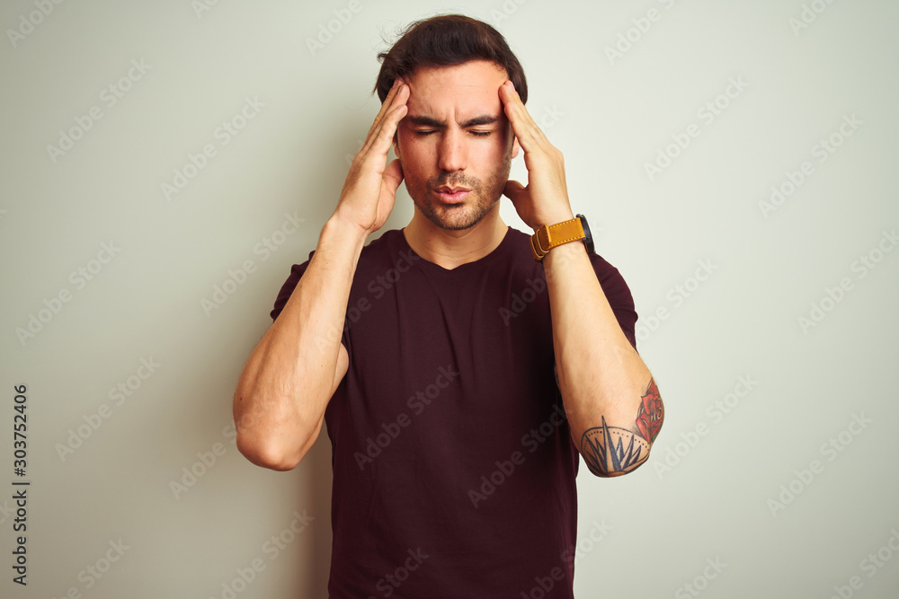 Φωτογραφία Young handsome man with tattoo wearing purple casual t-shirt over isolated white background with hand on head for pain in head because stress