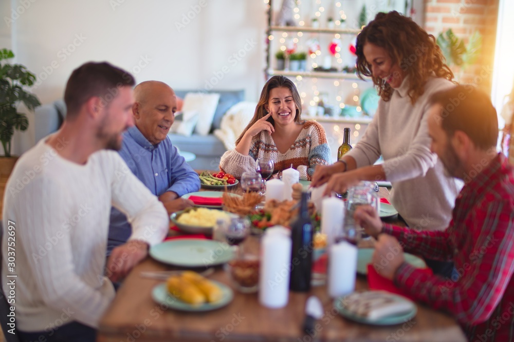 Beautiful family smiling happy and confident. Carving roasted turkey celebrating Christmas at home Beautiful family smiling happy and confident. Carving roasted turkey celebrating Christmas at home