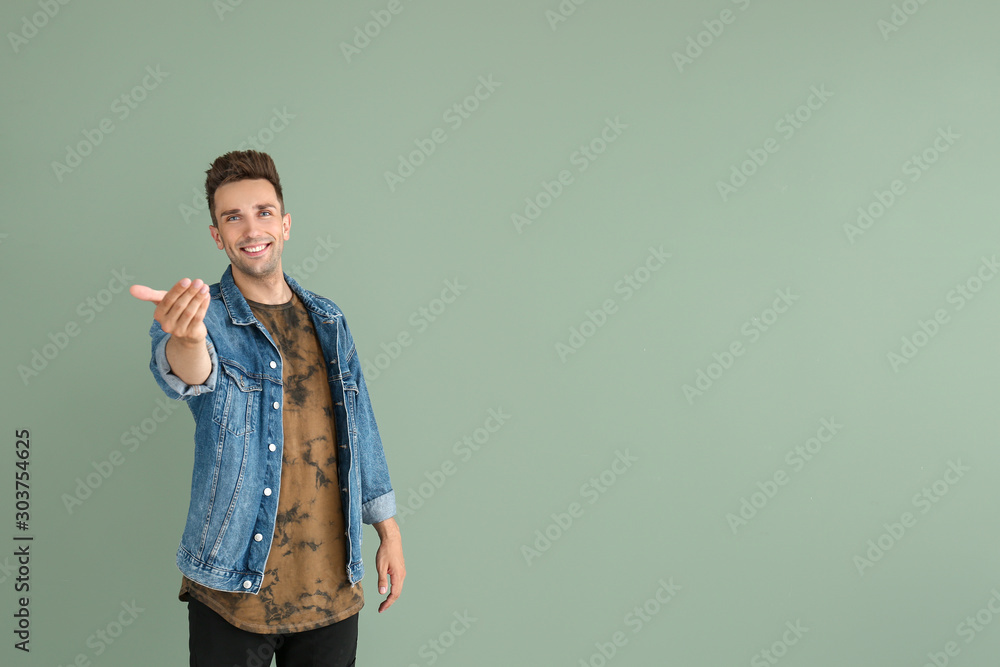 Fotografie Handsome young man inviting viewer on color background