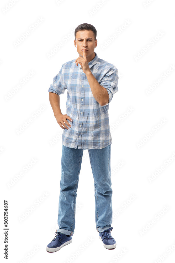 Portrait of handsome young man showing silence gesture on white background Portrait of handsome young man showing silence gesture on white background