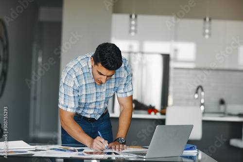 Handsome businessman in a office. Businessman in a blue shirt. Male with laptop. Young boy working