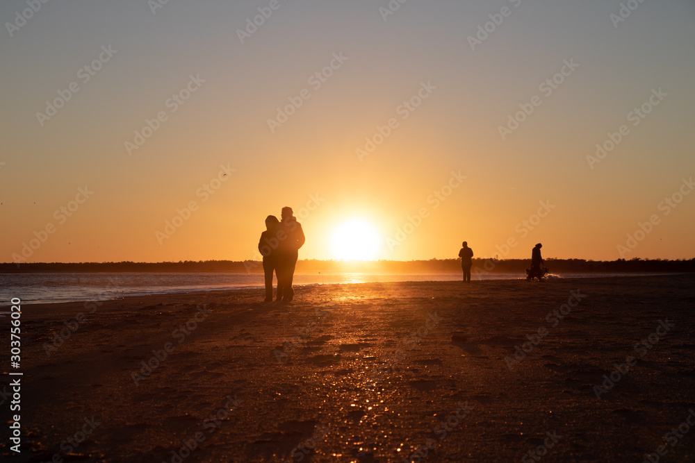 People scattered on beach at sunset People scattered on beach at sunset