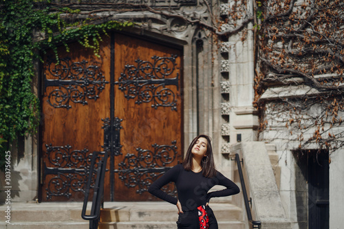 Vászonkép stylish brunette standing next to the entance to a building at University of Chi