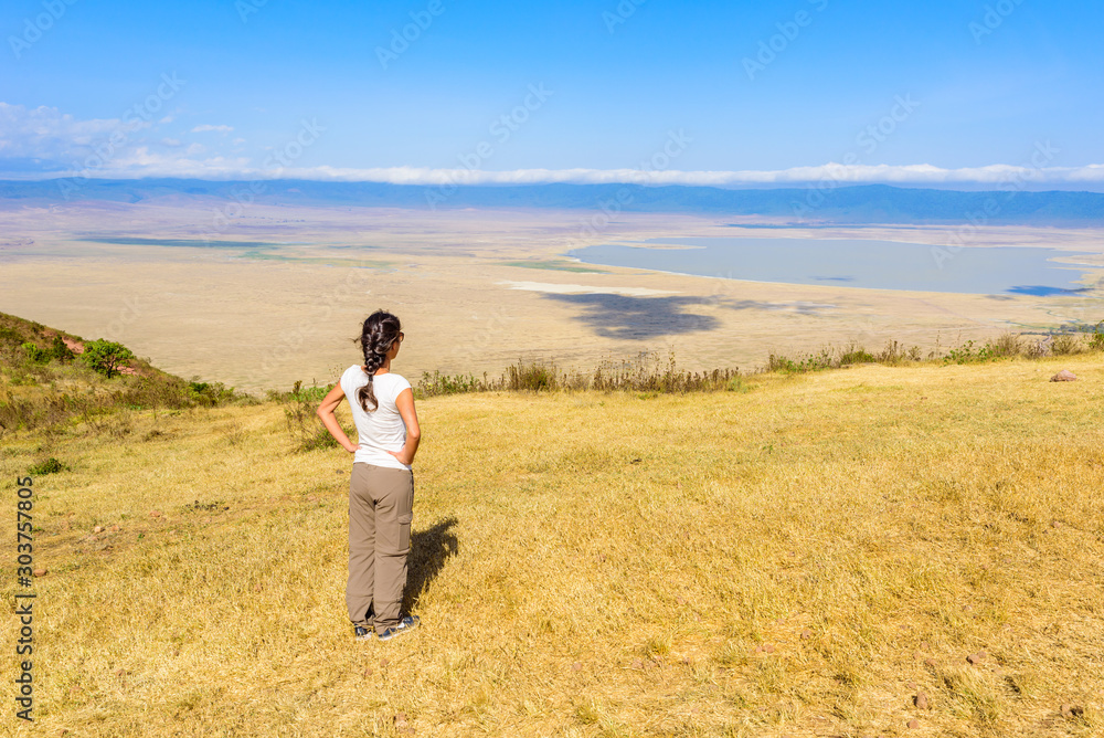 Tourist looks into the Ngorongoro crater National Park with the Lake Magadi. Safari Tours in Savannah of Africa. Beautiful landscape scenery in Tanzania, Africa