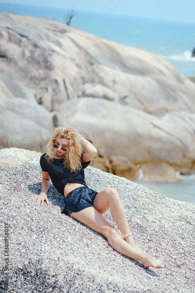 blonde girl practicing yoga on a rock by the beach blonde girl practicing yoga on a rock by the beach
