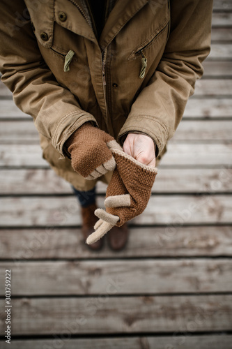 girl puts on her hands warm winter wool gloves
