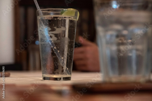 Glass of water with ice in restaurant background.