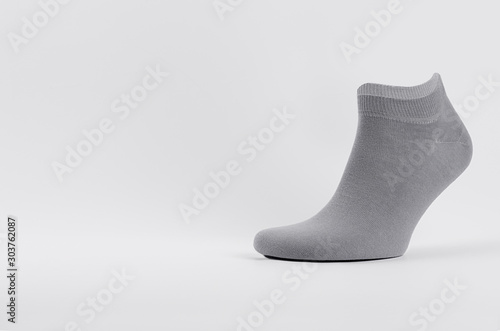 Blank grey cotton short sock on invisible foot on white background as mock up for advertising, branding, design, front view, template.
