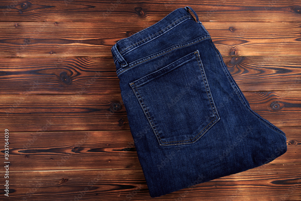 blue denim jeans on wooden background . blue denim jeans on wooden background .