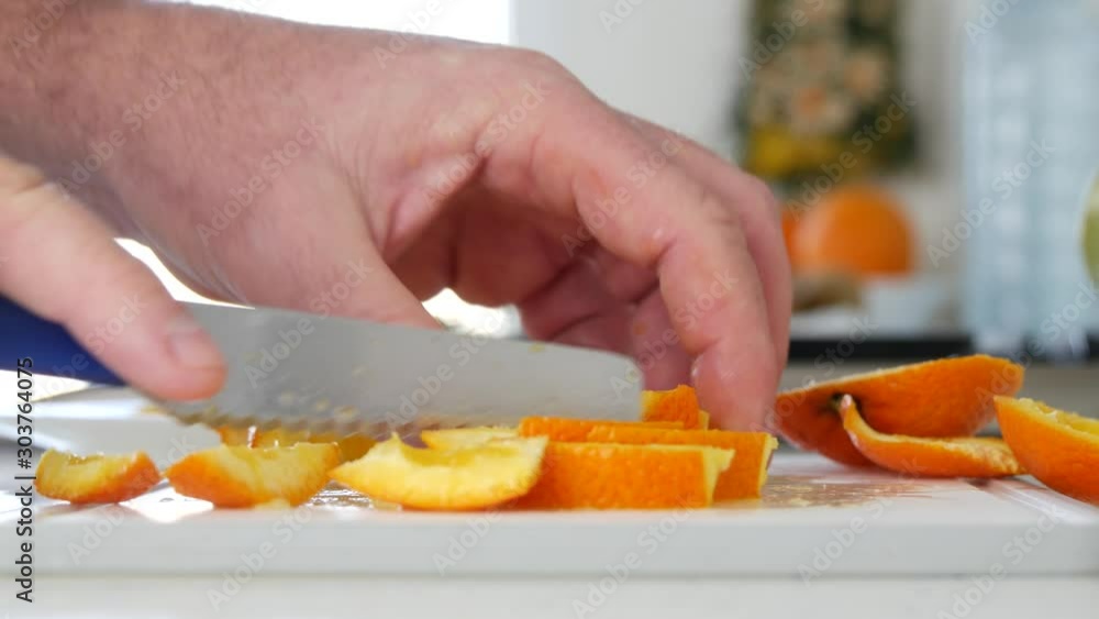 Close up Man Hand Cutting in Small Slices an Orange Close up Man Hand Cutting in Small Slices an Orange