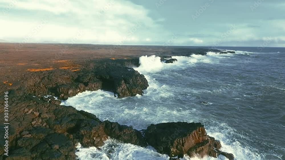 Powerful ocean waves crashing on the rocks in the western part of Iceland in the sunset light Powerful ocean waves crashing on the rocks in the western part of Iceland in the sunset light