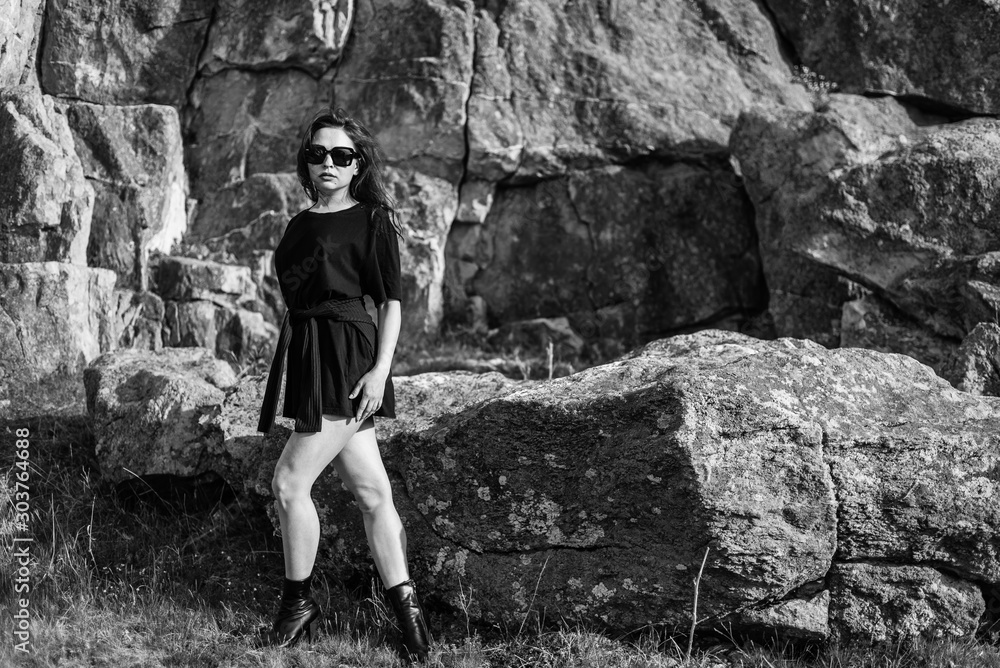 portrait of beautiful sexy brunette in sunglasses. fashionable young woman in short dress outdoors in Sunny weather enjoying summer. a man's t-shirt on a woman. portrait of beautiful sexy brunette in sunglasses. fashionable young woman in short dress outdoors in Sunny weather enjoying summer. a man's t-shirt on a woman.