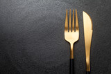 Fork and knife on a empty  black plate. Close-up.