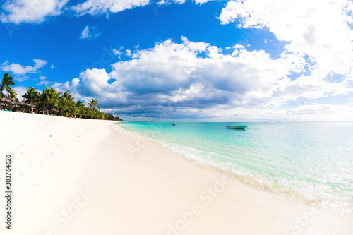 Tropical holiday beach with ocean, white sand, palm