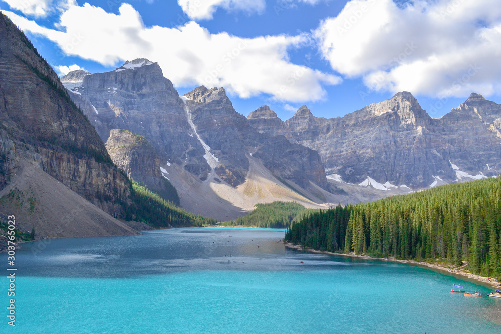 Iconic Canadian landscape, trip of a lifetime, Moraine Lake with it's glacier fed light blue turquoise waters and majestic peaks on a sunny day in the end of august, wilderness forest landscape.