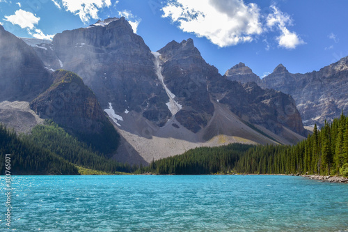 Iconic Canadian landscape, trip of a lifetime, Moraine Lake with it's glacier fed light blue turquoise waters and majestic peaks on a sunny day in the end of august, wilderness forest landscape.