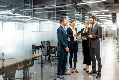 Photography Group of business people strictly dressed in the suits meeting in the hallway of