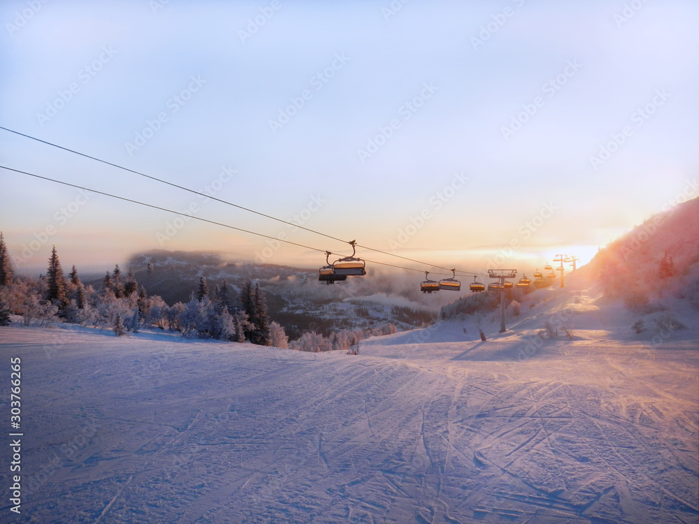 Ski slope and cable car at sunrise.