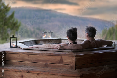 The young couple in an open-air bath with a view of the mountains.