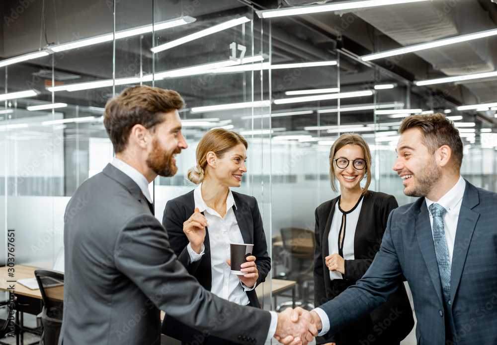 Φωτογραφία Business people strictly dressed in the suits meeting in the hallway of the mode