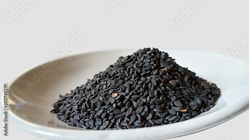black sesame seeds in a bowl isolated on white