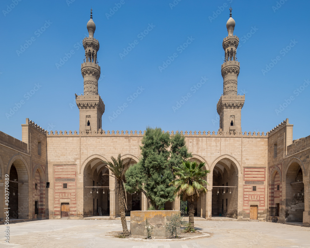 Courtyard of Mamluk era al Nasir Faraj ibn Barquq public historical mosque with minarets of the mosque, Al Darb Al Ahmar district, Cairo, Egypt