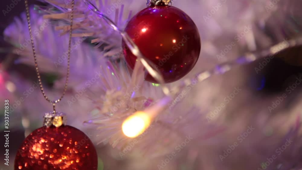 Christmas interior. Decoration of a white Christmas tree with red toys. Decorating on Christmas tree with ball. Dresses Christmas tree with ball lights. Christmas interior. Decoration of a white Christmas tree with red toys. Decorating on Christmas tree with ball. Dresses Christmas tree with ball lights.