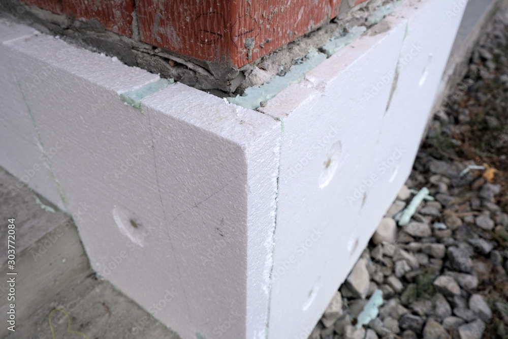 Close-up detail of brick house wall with rigid styrofoam insulation sheet. Modern technology of construction, renovation and energy saving. Alternative for mineral wool, warm comfortable house concept Close-up detail of brick house wall with rigid styrofoam insulation sheet. Modern technology of construction, renovation and energy saving. Alternative for mineral wool, warm comfortable house concept