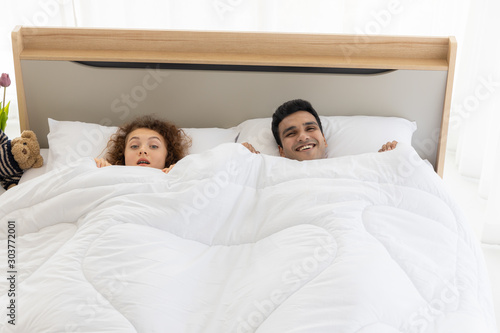 Lovely couple in duvet lying on the bed in bedroom