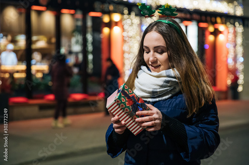 girl with a gift bag in her hands, emotional portrait, New Year's atmosphere, young beautiful girl at Christmas makes purchases and gifts