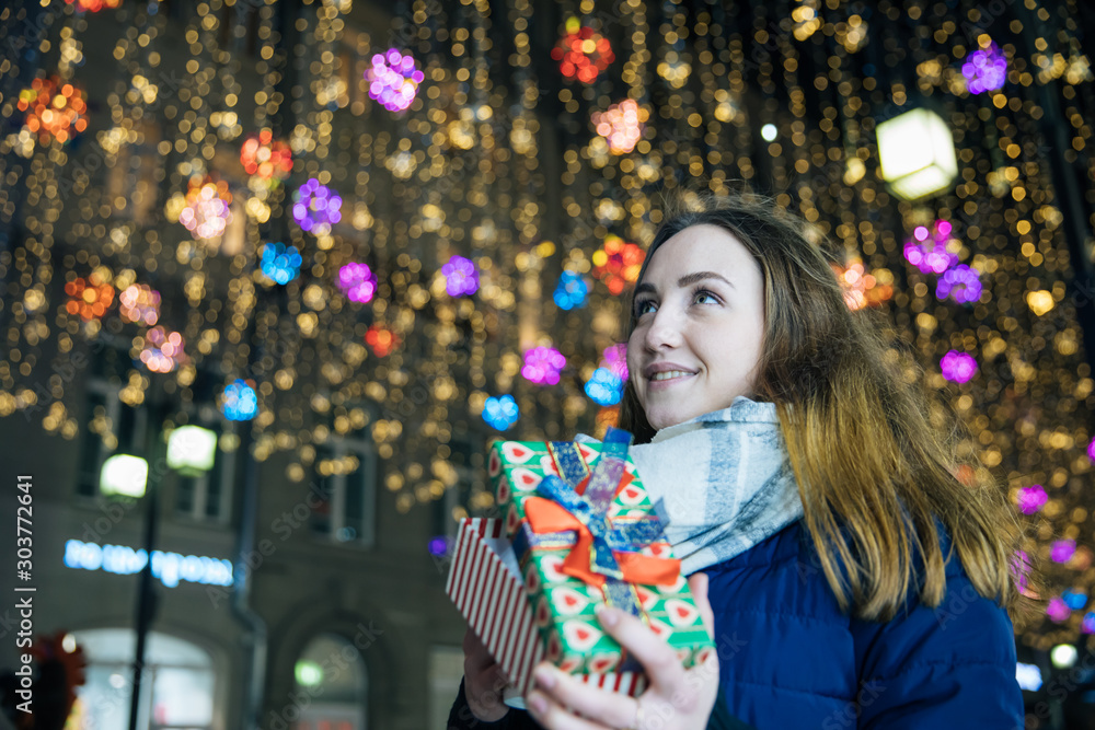 Φωτογραφία girl with a gift bag in her hands, emotional portrait, New Year's atmosphere, yo