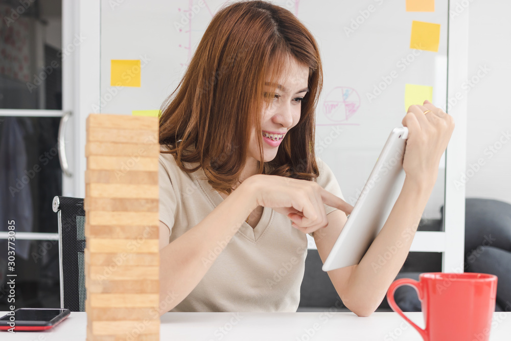 Attractive young Asian woman having fun with digital tablet in living room. Internet of things concept. Attractive young Asian woman having fun with digital tablet in living room. Internet of things concept.