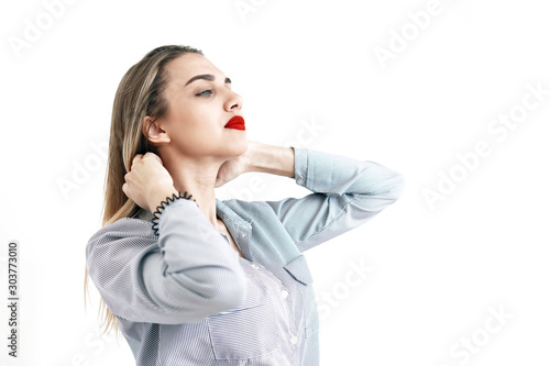 Young sexy blonde with bright lips straightens hair, white background