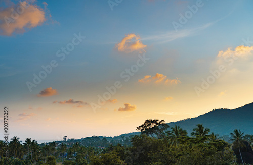 Spectacular sunset over trees and mountain on a tropical island