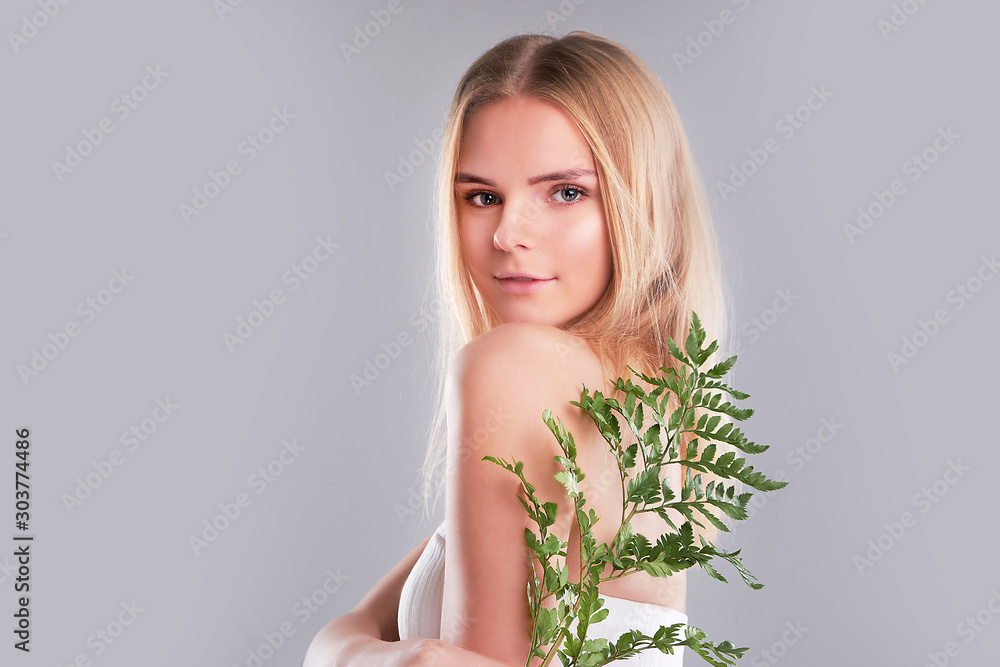 Naklejka premium Natural organic skin care, the concept of harmony with nature, green long fern leaves grass near the face. portrait of beauty ladies. Young beautiful woman with clean sparkling skin of face and body.