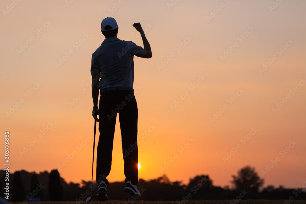 Fototapeta premium Sport Healthy. Golfing game. Asian man golfer action to win after long putting golf ball on the green golf, outdoors sunset time, space. Healthy Concept