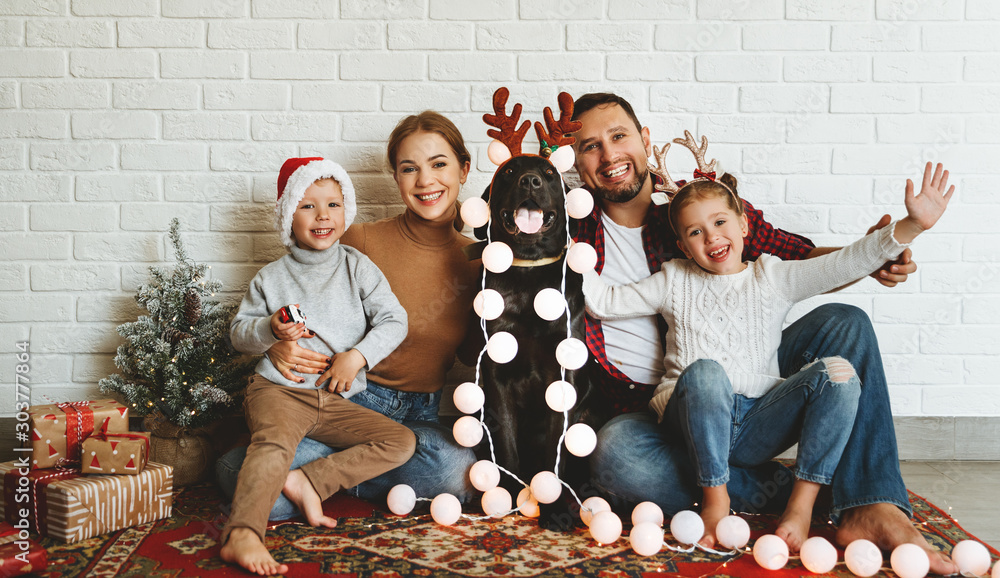 happy Christmas! family mother father and kids with dog before Christmas with garland   and tree. - obrazy, fototapety, plakaty 
