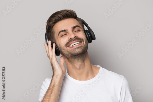 Close up portrait with handsome bearded man enjoying music.