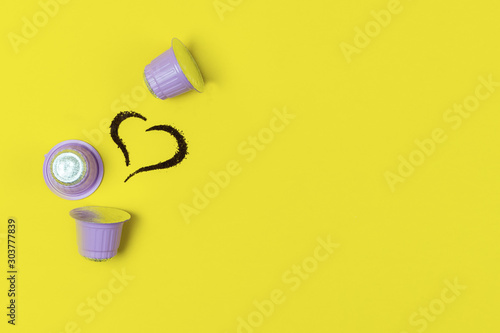 Coffee Concept Three Coffee Capsules and Heart made of Coffee on Yellow Background Love FlatLay Top View Copy Space