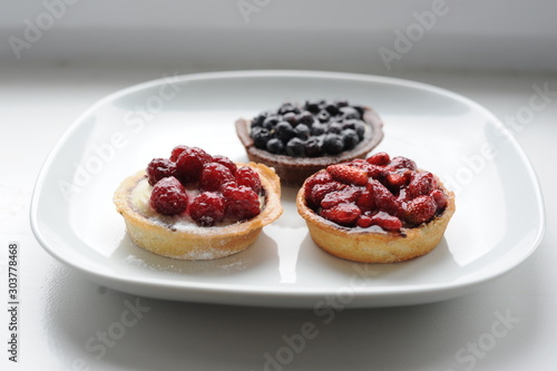 Healthy homemade fruit cookies with strawberries, blueberries, raspberries on a white plate