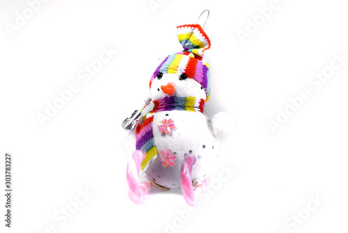Toy snowman on skis from a pink candy striped on a white background. Christmas souvenir.
