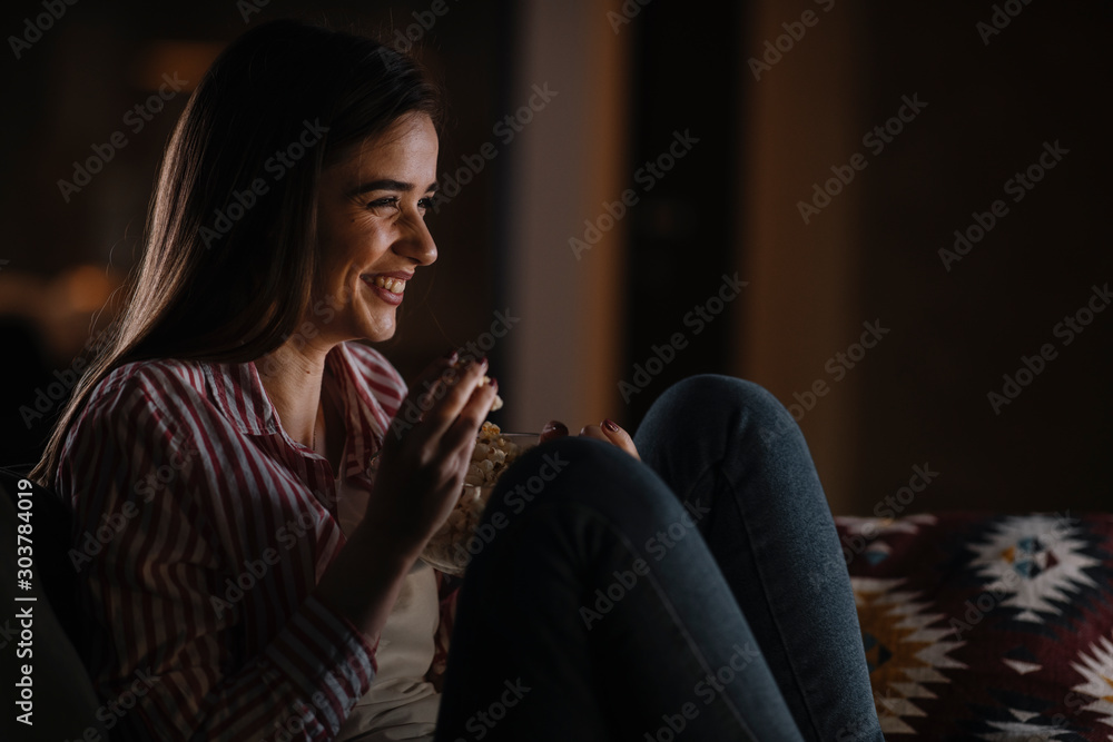 Young woman at home. Beautiful woman sitting in living room watching movie. Young woman at home. Beautiful woman sitting in living room watching movie.