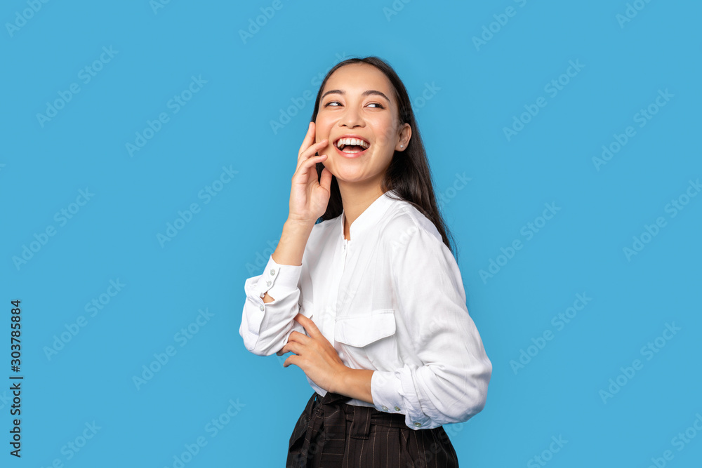 Freestyle. Young woman wearing shirt and skirt standing isolated on blue touching face laughing happy Freestyle. Young woman wearing shirt and skirt standing isolated on blue touching face laughing happy