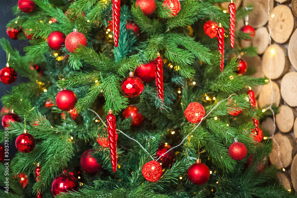 Background from a Christmas tree decorated in red and gold color close-up. Greeting card from a Christmas tree with red decorations and copy space. Details of a decorated Christmas tree with a frame f Background from a Christmas tree decorated in red and gold color close-up. Greeting card from a Christmas tree with red decorations and copy space. Details of a decorated Christmas tree with a frame f